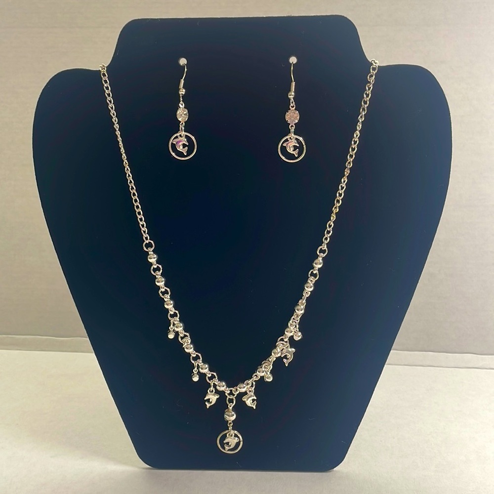 Silver tone dolphin necklace with matching earrings.